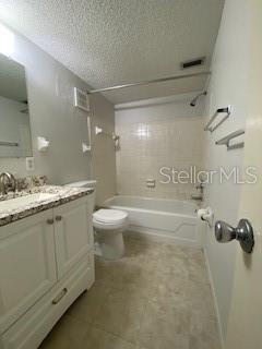 full bathroom with tiled shower / bath combo, vanity, a textured ceiling, and toilet