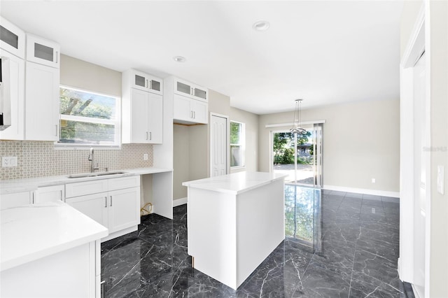 kitchen with white cabinets, sink, and a healthy amount of sunlight