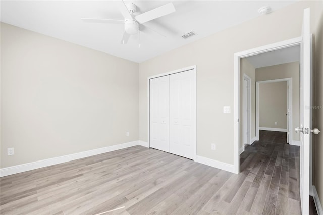 unfurnished bedroom featuring ceiling fan, a closet, and light hardwood / wood-style flooring