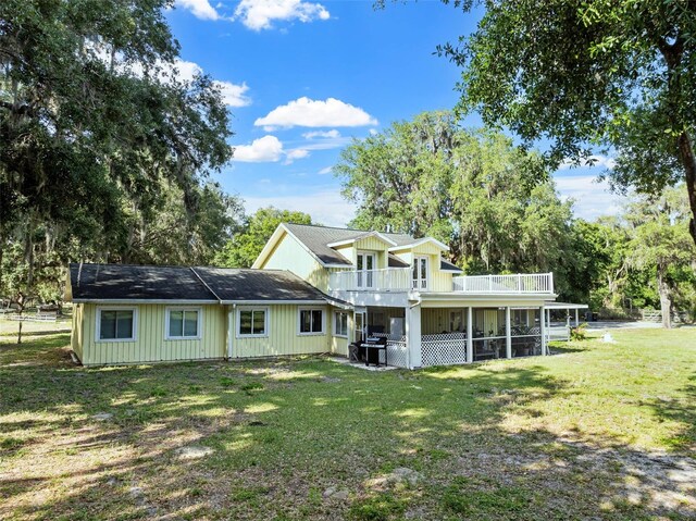 4350 E Hinson Ave, Haines City, FL 33844 - rear view of property with a balcony, a yard, a sunroom, and board and batten siding