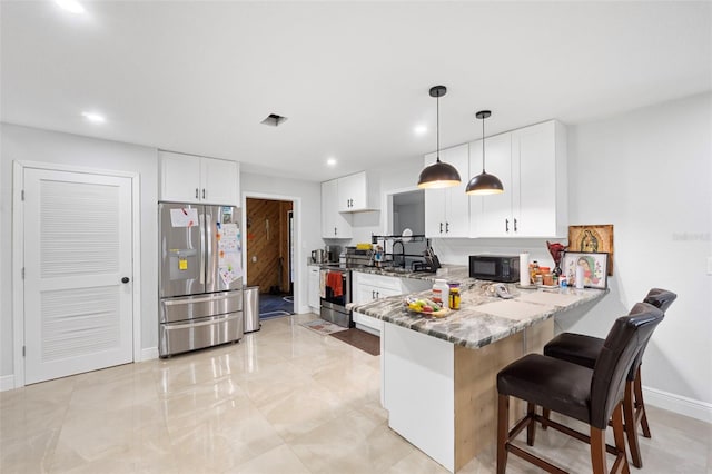 kitchen featuring hanging light fixtures, white cabinetry, light stone counters, kitchen peninsula, and stainless steel appliances