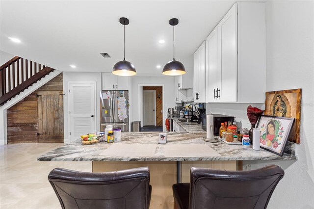 4350 E Hinson Ave, Haines City, FL 33844 - kitchen featuring stainless steel fridge, a peninsula, white cabinetry, light stone countertops, and recessed lighting