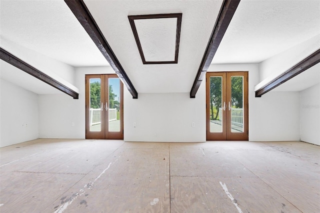 bonus room with french doors, a textured ceiling, and a healthy amount of sunlight