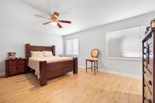 bedroom featuring a textured ceiling, light hardwood / wood-style floors, and ceiling fan