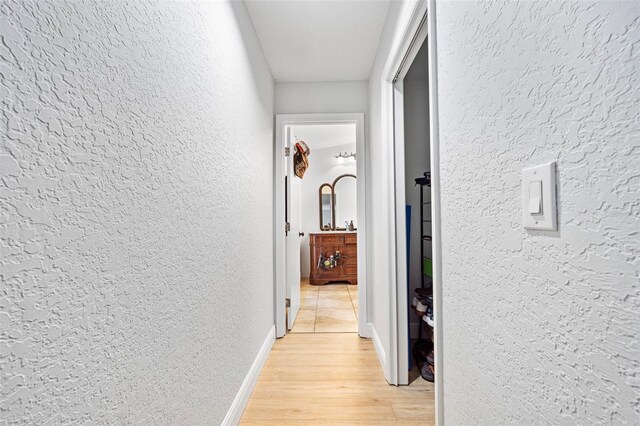 4350 E Hinson Ave, Haines City, FL 33844 - corridor with a textured wall, light wood-style floors, and baseboards