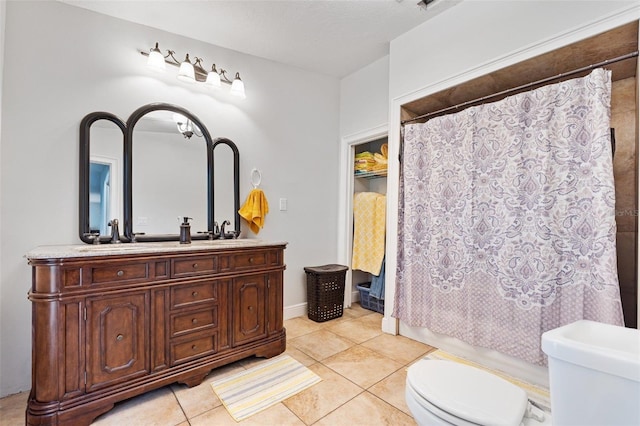 bathroom with a shower with curtain, vanity, toilet, and tile patterned floors