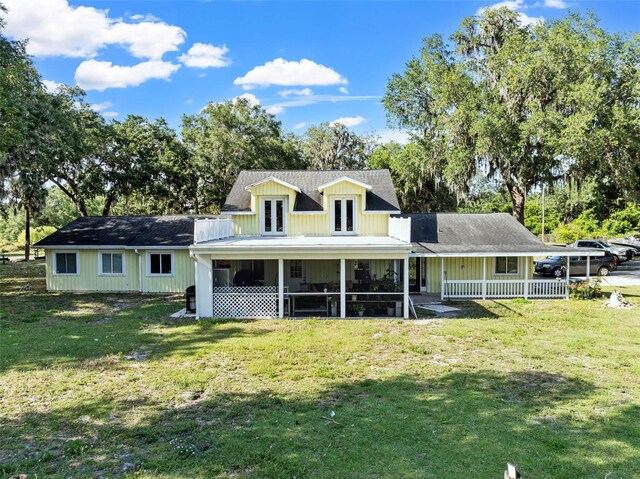 4350 E Hinson Ave, Haines City, FL 33844 - rear view of house with french doors, a lawn, a sunroom, and view of wooded area