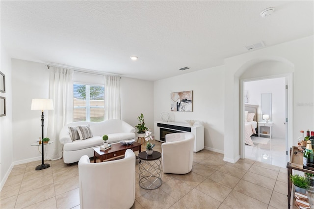 living room featuring a textured ceiling and light tile patterned floors