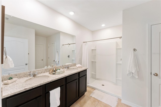 bathroom featuring tile patterned flooring, vanity, and curtained shower