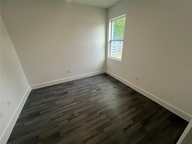 spare room with dark wood-type flooring