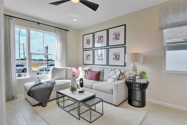 living room with light hardwood / wood-style flooring and ceiling fan