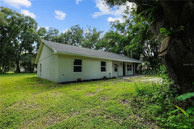 rear view of property featuring a yard