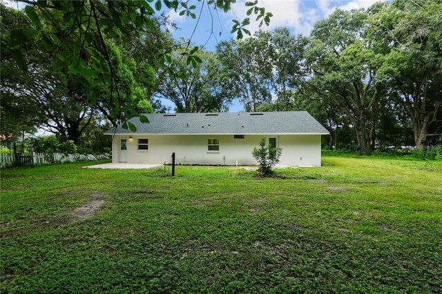 rear view of house featuring a yard and a patio