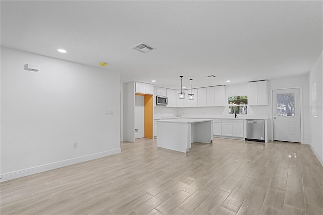 unfurnished living room featuring light wood-type flooring, a textured ceiling, and sink