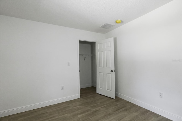 unfurnished bedroom with a textured ceiling and hardwood / wood-style floors