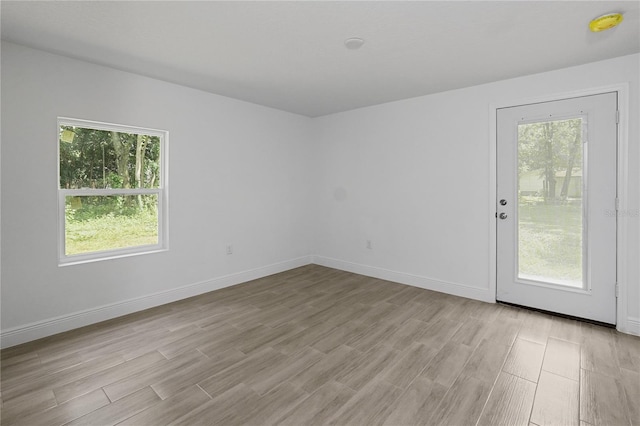 unfurnished room with light wood-type flooring and plenty of natural light