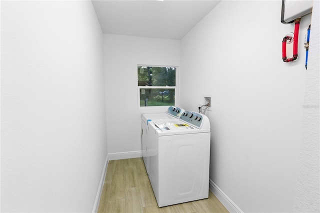 laundry room featuring washer and clothes dryer and light hardwood / wood-style floors