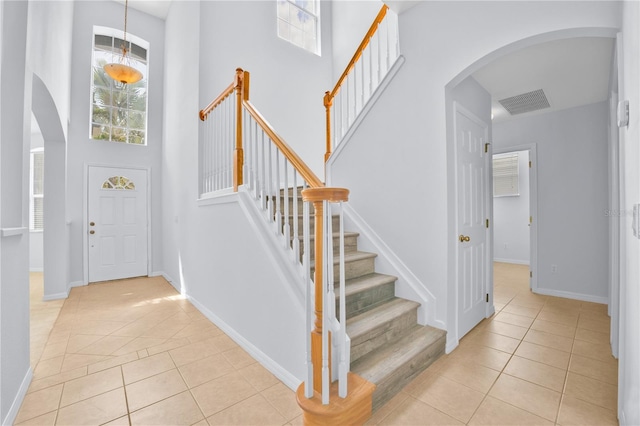 tiled foyer entrance with a towering ceiling