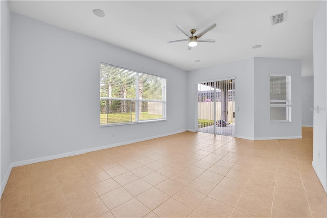 tiled spare room with ceiling fan