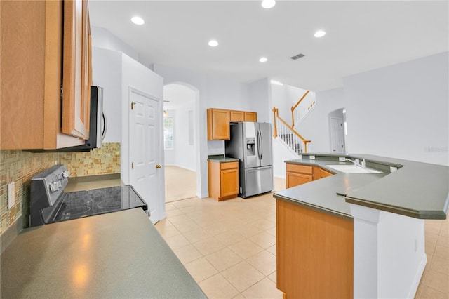 kitchen featuring tasteful backsplash, light tile patterned floors, appliances with stainless steel finishes, and sink