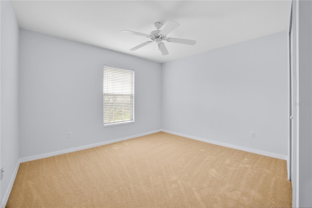 carpeted spare room featuring ceiling fan