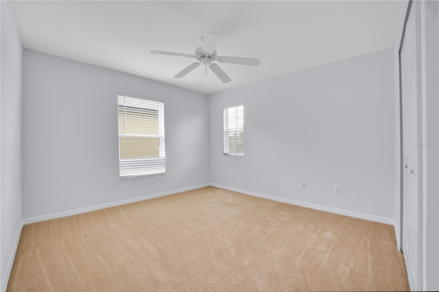 carpeted spare room featuring ceiling fan