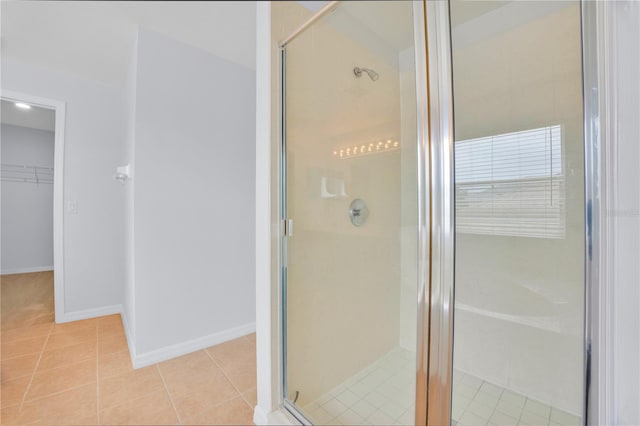 bathroom with a shower with shower door and tile patterned floors