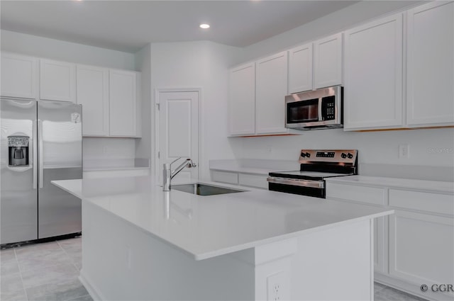 kitchen featuring an island with sink, stainless steel appliances, white cabinetry, and sink