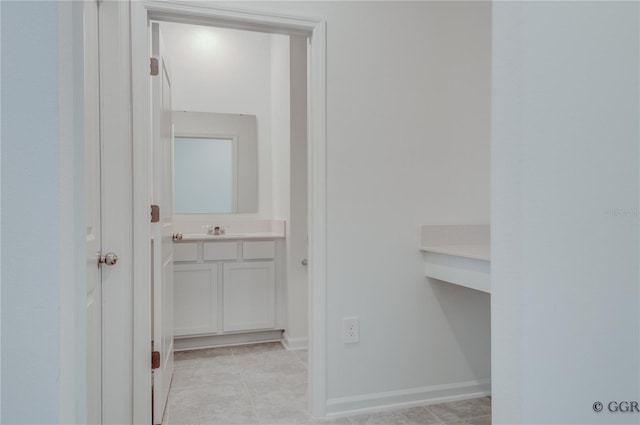 corridor with sink and light tile patterned floors