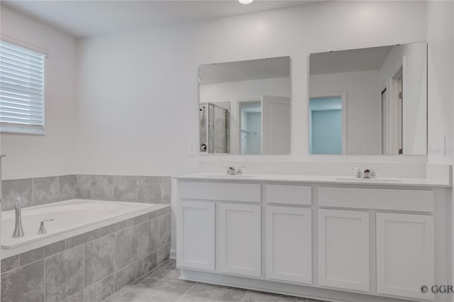 bathroom featuring shower with separate bathtub, vanity, and tile patterned floors