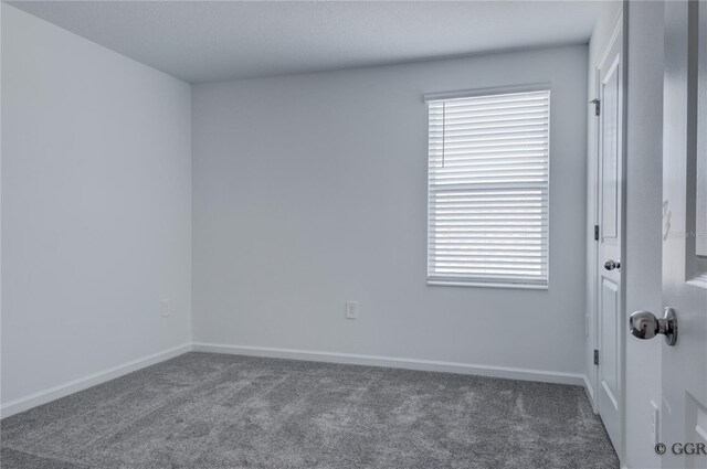 empty room with dark colored carpet