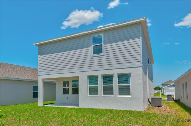 back of property featuring a lawn, central AC unit, and a patio area