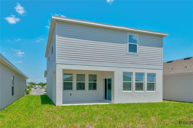 rear view of property featuring a patio and a yard