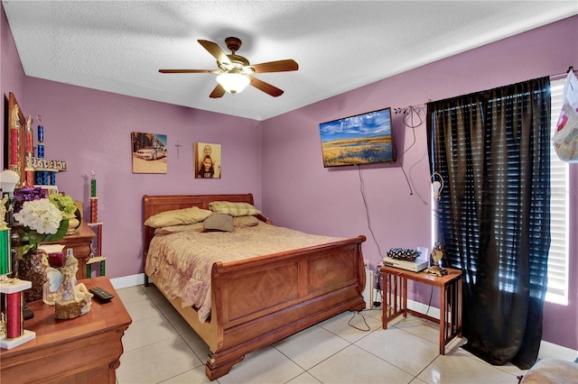 bedroom with ceiling fan, a textured ceiling, and light tile patterned floors