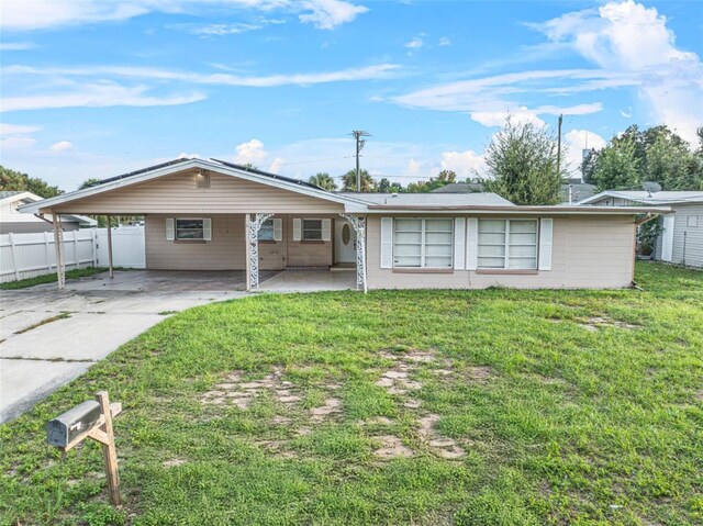 912 Ave T SE, Winter Haven, FL 33880 - ranch-style house featuring a carport, driveway, fence, and a front lawn