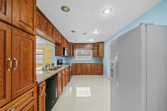912 Ave T SE, Winter Haven, FL 33880 - kitchen with light tile patterned floors, glass insert cabinets, visible vents, appliances with stainless steel finishes, and a sink
