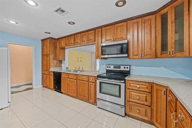 912 Ave T SE, Winter Haven, FL 33880 - kitchen with visible vents, brown cabinetry, and appliances with stainless steel finishes