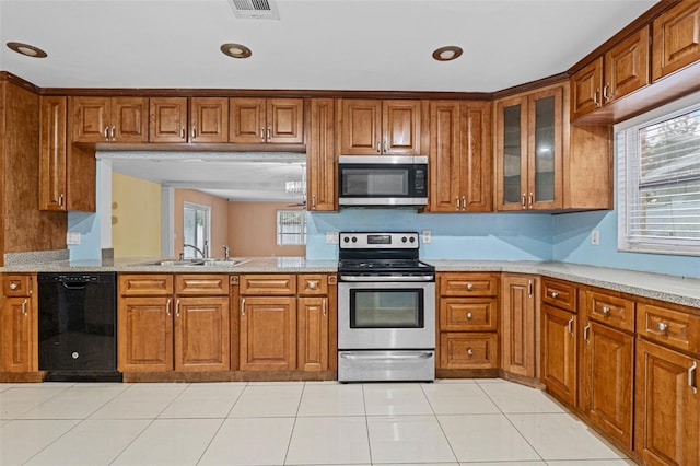 kitchen featuring light stone counters, light tile patterned floors, appliances with stainless steel finishes, and sink