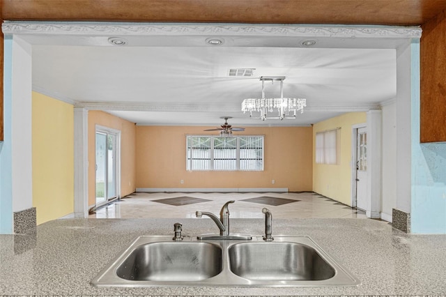 kitchen with ceiling fan with notable chandelier, decorative columns, sink, and pendant lighting