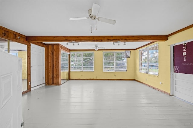 interior space featuring track lighting, wooden walls, and light hardwood / wood-style floors