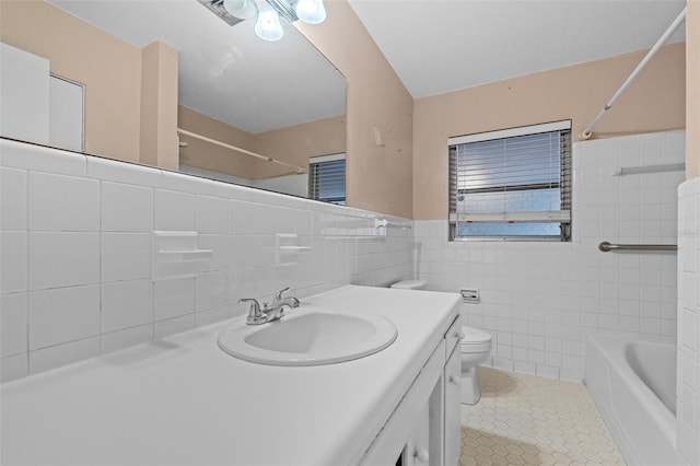 full bathroom featuring tile walls, tile patterned flooring, tiled shower / bath combo, vanity, and toilet