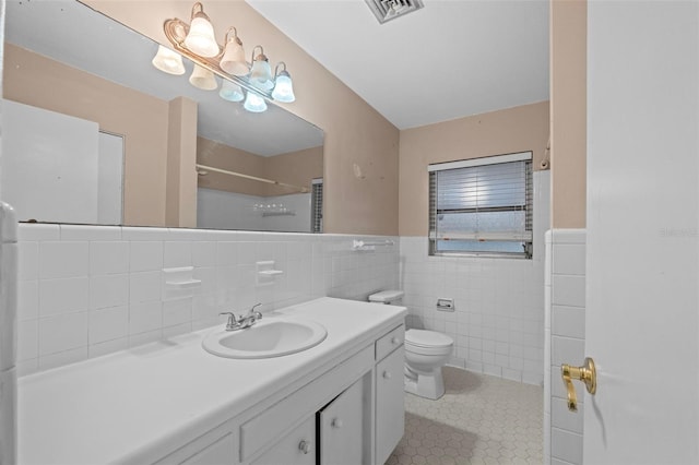 bathroom with vanity, tile patterned floors, a shower with curtain, tile walls, and toilet