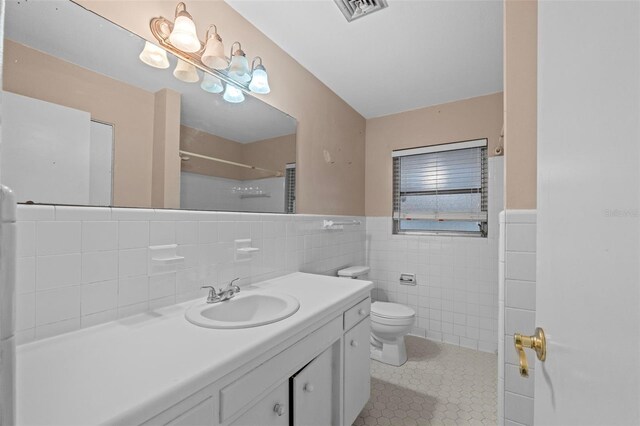 912 Ave T SE, Winter Haven, FL 33880 - bathroom with tile patterned flooring, toilet, visible vents, a shower, and tile walls