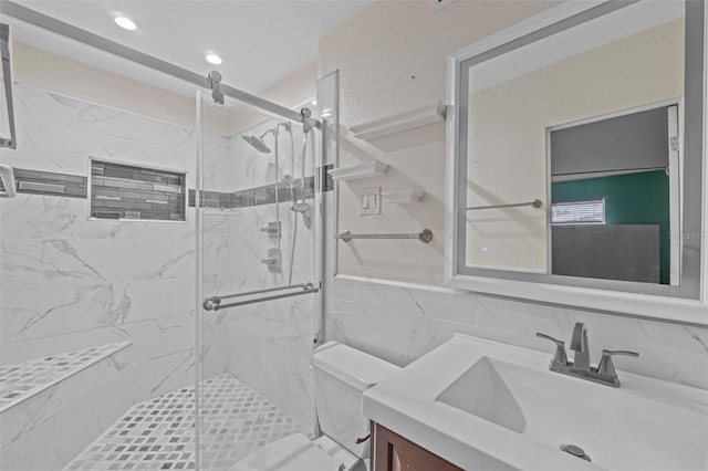 bathroom with tile walls, vanity, and an enclosed shower