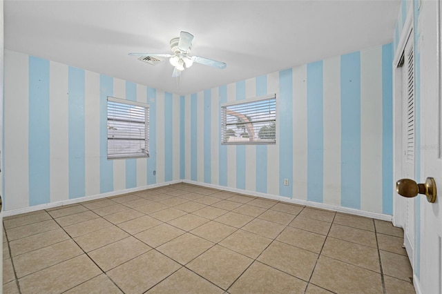 spare room with ceiling fan and light tile patterned floors