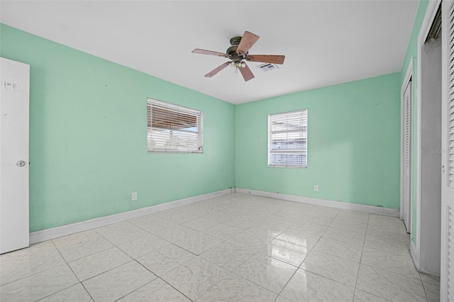 unfurnished bedroom with multiple windows, light tile patterned flooring, ceiling fan, and a closet