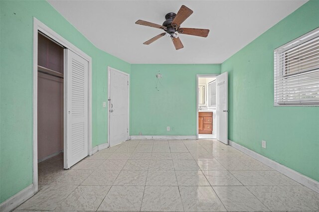 912 Ave T SE, Winter Haven, FL 33880 - unfurnished bedroom featuring a closet, baseboards, ceiling fan, and ensuite bathroom