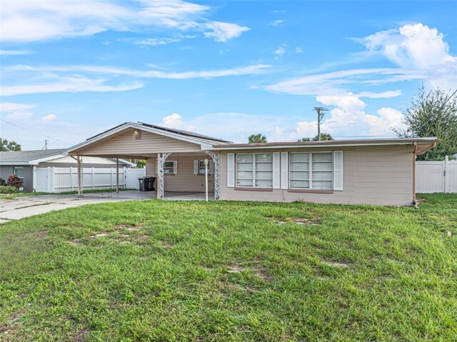 912 Ave T SE, Winter Haven, FL 33880 - single story home with fence, solar panels, a front lawn, concrete driveway, and an attached carport