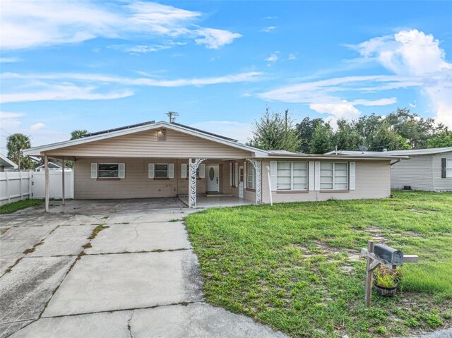 912 Ave T SE, Winter Haven, FL 33880 - ranch-style house featuring a carport, driveway, fence, and a front lawn