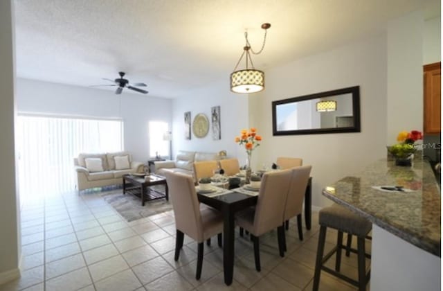 tiled dining room featuring ceiling fan